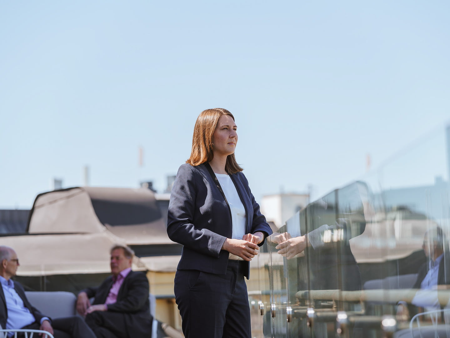 Portrait of Larissa Salo with other lawyers discussing in the background.